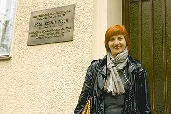 Die heutige Besitzerin Monika Stratmann neben einer Gedenktafel an Egon Erwin Kisch