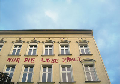 Sanierte Altbaufassade mit der gesprühten Aufschrift 'Nur die Liebe zählt'