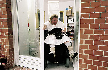 Rollstuhlfahrerin Marina W. kämpft mit der Barriere Tür