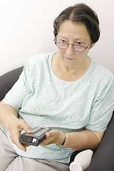 Seniorin mit Fernbedienung - Kommunikation via Fernsehgerät
