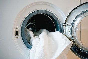 Wäsche wird in eine Waschmaschine geladen