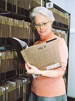 Eine Frau studiert eine ALG-II-Akte