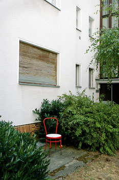Gartenstuhl zwischen wuchernden Pflanzen im Garten der Windscheidstraße in Charlottenburg
