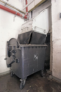 Mülltonne unterhalb einer Müllabwurfanlage