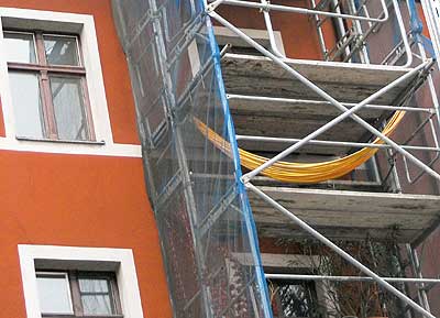 Eine Hängematte, befestigt an einem Baugerüst vor einer Altbaufassade