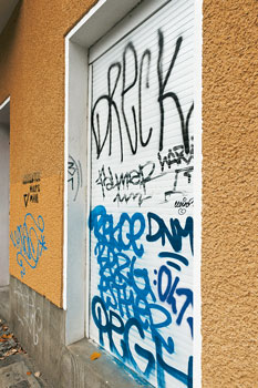 Graffiti auf Hausfassade und Jalousie
