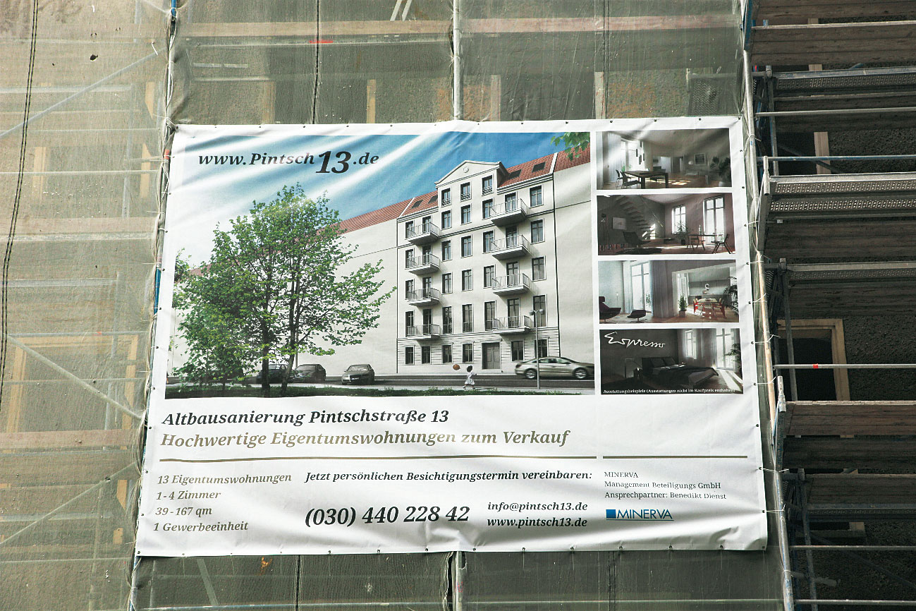 Werbeplakat für Eigentumswohnungen an einem Baugerüst