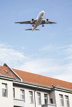 Flugzeug im Landeanflug über Wohnhäusern