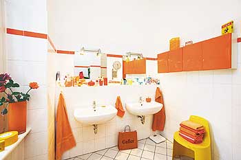 Badezimmer in orange und gelb mit Doppelwaschbecken
