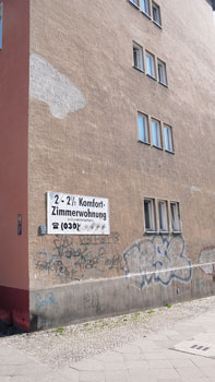 Plakat an Altbaufassade mit der Inschrift '2 - 2 1/2-Komfort-Zimmerwohnung zu vermieten'