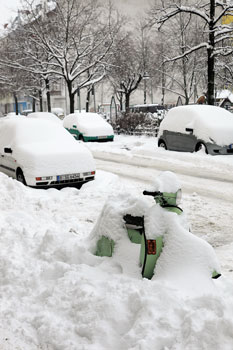 Winterliche Straße mit eingeschneiten parkenden Autos