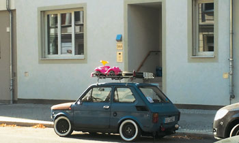 Ein Bobbycar auf dem Dachgepäckträger eines Kleinwagens