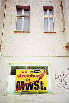 Plakat im Fenster eines Hauses mit der Aufschrift: Wir streichen die MwSt.