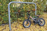 Kinderfahrrad lehnt an Fahrradbügel für 'erwachsene' Fahrräder