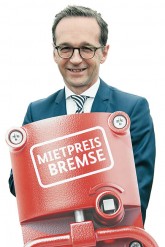 Justizminister Heiko Maas hält symbolisch eine 'Mietpreisbremse'