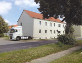 LKW parkt dicht an Hausfassade