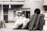 Brikett-Kiepen und Säcke mit Brennholz vor einer historischen Brennstoffhandlung