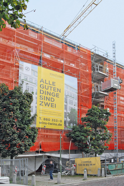 Eingerüstetes Haus mit einem großen Werbeplakat