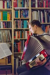 Akkordeonspieler in der häuslichen Bibliothek