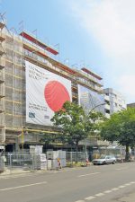 Eingerüstetes Haus mit Großplakaten