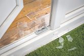 Zerschlagene Balkontür und Glasscherben