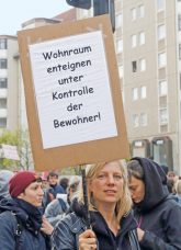 Demonstrantin mit Protestplakat