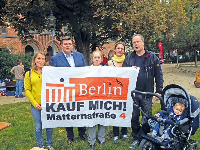 Mieter mit Plakat 'Kauf mich'