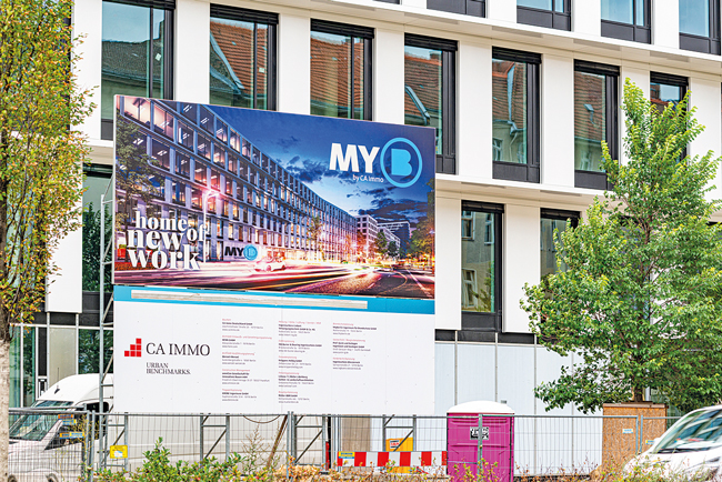 Immobilienplakat vor einem Neubau Immobilienplakat vor einem Neubau