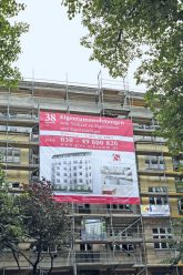 Wohngebäude mit Werbeplakat für Eigentumswohnungen