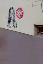 Wandzeichnung: Frau mit Mundschutz und Corona-Signet