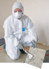Handwerker beim Entfernen von Vinyl-Asbest-Platten
