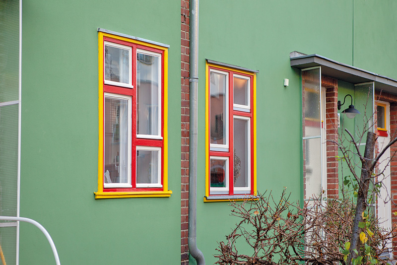 Grüne Fassade mit farbig abgesetzten Fensterrahmen Grüne Fassade mit farbig abgesetzten Fensterrahmen