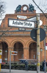 Straßenschild ,Anhalter Straße‘ mit Bahnhofsportal im Hintergrund