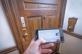 Smartphone-Eingabe vor verschlossener Wohnungstür