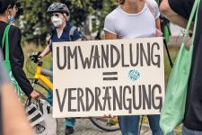 Demonstranten mit Plakat ,Umwandlung = Verdrängung‘