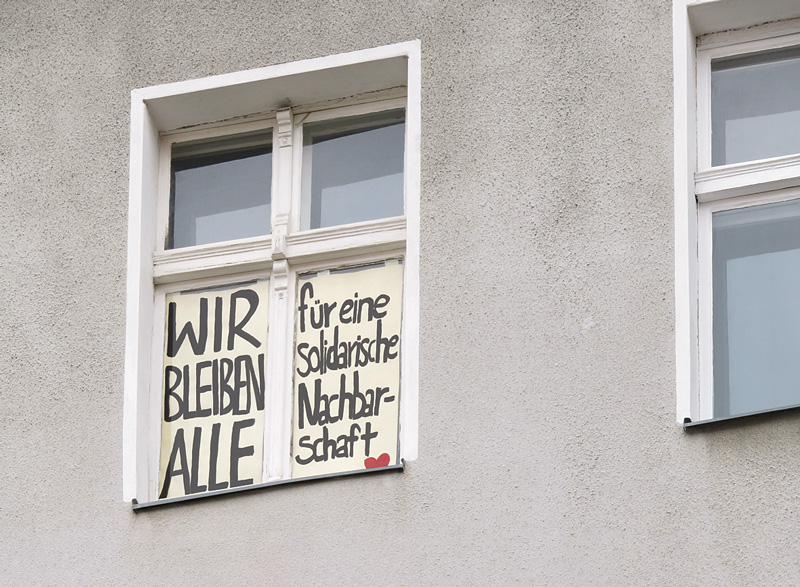 Protestplakat im Fenster: Wir bleiben alle