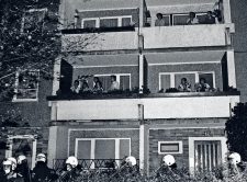 Behelmte Polizei und Bewohner auf dem Balkon