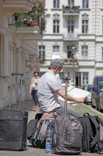 Man mit diversen Gepäckstücken