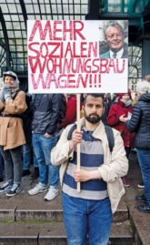 Demonstrant mit Plakat: Mehr Sozialen Wohnungsbau wagen Demonstrant mit Plakat: Mehr Sozialen Wohnungsbau wagen