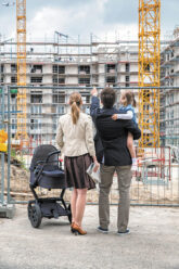Familie vor einem im Bau befindlichen Wohnblock Familie vor einem im Bau befindlichen Wohnblock
