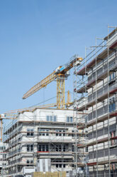 Gebäude im Bau mit Kran und Gerüsten