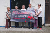 Bewohner des Hauses mit Protesttransparent